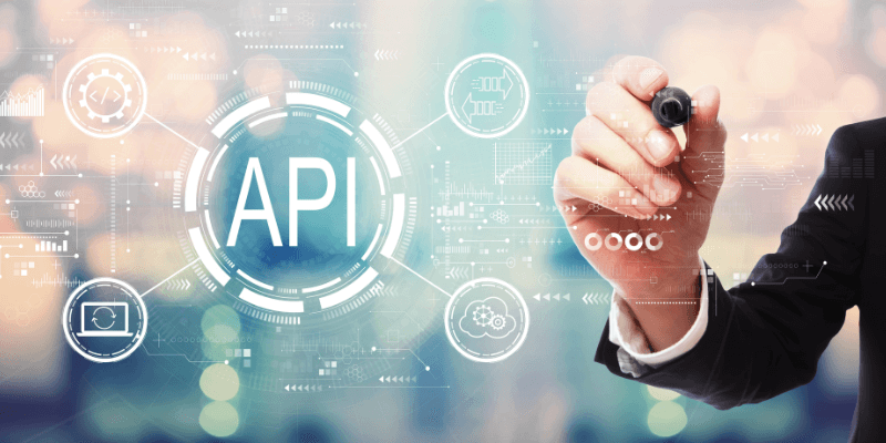 Businessman writing with a marker, with API integration graphic overlaid