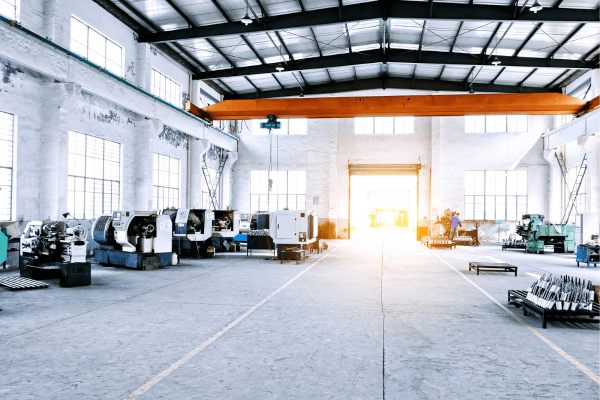 A brightly lit factory floor, with manufacturing robots lined up